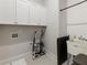 Laundry room with white cabinets, utility sink, and ample storage at 775 Stickley Oak Way, Woodstock, GA 30189