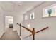 Upstairs hallway with carpeting, wood railing, and access to bedrooms at 5531 Pine Aly, Lithonia, GA 30058