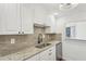 Modern kitchen with granite countertops and white cabinets at 622 Powers Ferry North Se, Marietta, GA 30067