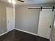 Bedroom with dark hardwood floors and barn door at 4664 Ryan Rd, Conley, GA 30288