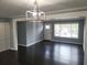 Spacious living area with dark hardwood floors and updated light fixture at 4664 Ryan Rd, Conley, GA 30288