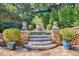 Stone steps leading to a charming garden with lush greenery and unique planters at 23 Paces West, Atlanta, GA 30327