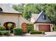 House exterior featuring a charming, two-toned design, attached garage, and manicured landscaping at 23 Paces West, Atlanta, GA 30327