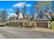 Charming home with a European-inspired design, detailed with an arched garage and manicured landscaping at 23 Paces West Dr, Atlanta, GA 30327