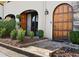 Elegant home entrance featuring a detailed arched wooden door and lush green landscaping at 23 Paces West Dr, Atlanta, GA 30327