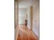 Hallway featuring gleaming hardwood floors, fresh paint, and beautiful trim, and white doors with brass hardware at 23 Paces West Dr, Atlanta, GA 30327