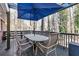 Outdoor deck with table, chairs, and umbrella, overlooking wooded area at 3251 Wanda Woods Dr, Atlanta, GA 30340