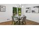 Bright dining area with glass table and four chairs, hardwood floors, and view of backyard at 1921 Westwood Sw Ave, Atlanta, GA 30310