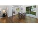 Bright dining area with hardwood floors, glass dining table, and sliding glass doors to the backyard at 1921 Westwood Sw Ave, Atlanta, GA 30310