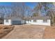 Newly renovated single-story home with a large driveway and mature trees at 1990 Old Concord Se Dr, Covington, GA 30016