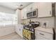 Well-lit kitchen equipped with stainless steel stove and microwave, and white cabinets at 2649 Santa Barbara Nw Dr, Atlanta, GA 30318