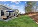 Beautifully landscaped backyard with lush grass, patio area with outdoor dining set, and well-maintained landscaping at 535 Cape Ivey Dr, Dacula, GA 30019