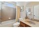 Well-lit bathroom featuring a combined shower and tub, neutral tile, vanity with sink, and ample storage space at 535 Cape Ivey Dr, Dacula, GA 30019