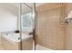 Modern bathroom featuring tiled walls, a glass-enclosed shower, and separate tiled tub with relaxing garden view at 535 Cape Ivey Dr, Dacula, GA 30019