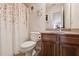 Cozy bathroom featuring floral-themed shower curtain, vanity, and a view into an adjacent room creating a relaxing atmosphere at 535 Cape Ivey Dr, Dacula, GA 30019