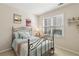 Cozy bedroom with vintage decor, a comfortable iron frame bed, and a bright window bringing natural light at 535 Cape Ivey Dr, Dacula, GA 30019