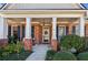 Inviting front porch with brick columns, a welcoming wreath, and lovely landscaping, perfect for relaxing at 535 Cape Ivey Dr, Dacula, GA 30019