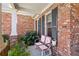 Cozy side porch featuring brick, black shutters and a cute swing for enjoying outdoor moments at 535 Cape Ivey Dr, Dacula, GA 30019