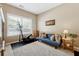 Room with elliptical machine, blue sofa, and large window at 724 Landsdowne Ln, Locust Grove, GA 30248
