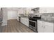 Modern kitchen with white cabinets, granite countertops, and stainless steel appliances at 1352 Jennie Sw Ln, Lilburn, GA 30047