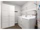 Bright laundry room with washer, dryer, and ample shelving at 1352 Jennie Sw Ln, Lilburn, GA 30047