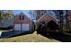 Charming brick home featuring an attached two-car garage and a well-manicured lawn at 1432 Cutters Mill Dr, Lithonia, GA 30058