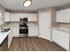 Modern kitchen with white cabinets, stainless steel appliances, and hardwood floors at 2114 Black Oak Ln, Ellenwood, GA 30294
