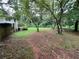 Partially grassy backyard with mature trees at 2323 Valleyside Dr, Decatur, GA 30032