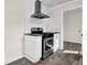 Close up of gas range stove and oven with exhaust fan over tile backsplash in white kitchen at 3413 Canadian Way, Tucker, GA 30084