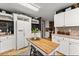 Bright kitchen with white cabinets and wooden island at 6045 Mockingbird Rd, Cumming, GA 30028