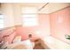 Bathroom with pink tile, a tub, and a window at 1351 Harbin Rd, Atlanta, GA 30311