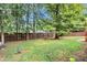 Large backyard with wooden fence and mature trees at 1450 Grovehurst Dr, Marietta, GA 30062