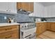 Modern kitchen features stainless steel range, light oak cabinets, and blue tile backsplash at 1565 Pineview Terrace Sw, Atlanta, GA 30311