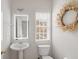 Clean and updated half bathroom with pedestal sink and decorative wreath at 2428 Bridlewood Se Dr # 24, Atlanta, GA 30339