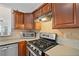 Close up view of the gas range, microwave, and wood cabinetry in the kitchen at 2428 Bridlewood Se Dr # 24, Atlanta, GA 30339