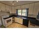 White kitchen cabinets, black countertops, and white appliances at 425 Hilderbrand Dr, Sandy Springs, GA 30328