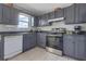 Kitchen with gray cabinets, stainless steel appliances, and granite countertops at 6460 Dove Dr, Loganville, GA 30052