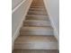 Carpeted staircase with white railing and neutral walls at 35 Heyman Dr, Covington, GA 30016