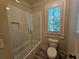 Bathroom with a shower/tub combo, tile surround, and wood-look flooring at 5981 Brundage Ln, Norcross, GA 30071