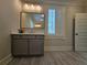 Single vanity bathroom with grey cabinets and wood-look tile flooring at 5981 Brundage Ln, Norcross, GA 30071