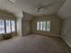 Bright and airy bedroom with neutral carpeting, ceiling fan, and large windows at 5981 Brundage Ln, Norcross, GA 30071