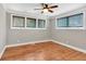 Bedroom with hardwood floors, three windows, ceiling fan, and neutral color paint at 4847 Lakewood Dr, Acworth, GA 30101