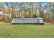 Backyard greenhouse with overgrown lawn and wooded surround at 4847 Lakewood Dr, Acworth, GA 30101