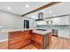 Open kitchen with a wood-clad kitchen island with cooktop, white cabinetry, and modern appliances at 4847 Lakewood Dr, Acworth, GA 30101