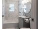 Updated bathroom featuring a shower over tub, stylish vanity and round mirror at 1268 Kenilworth Sw Dr, Atlanta, GA 30310