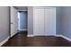 A modern bedroom with gray walls, wood-look floors, a closet with sliding doors, and a white door that leads to another room at 1268 Kenilworth Sw Dr, Atlanta, GA 30310