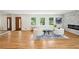 Bright living room with hardwood floors, white furniture, and a stone fireplace offers a modern and inviting space at 2139 Cedarbrook Se Ct, Atlanta, GA 30316
