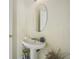 Small bathroom with pedestal sink and round mirror at 4414 Parmalee Path, Conley, GA 30288