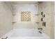 Elegant bathroom featuring a soaking tub, marble tile, and a mosaic accent wall at 2870 Pharr Court South Nw # 1205, Atlanta, GA 30305