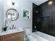 Bathroom with black tile, white bathtub and gold fixtures at 120 Howard Se St, Atlanta, GA 30317
